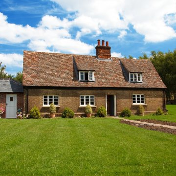 a front view of an older house with a lawn that might need some work